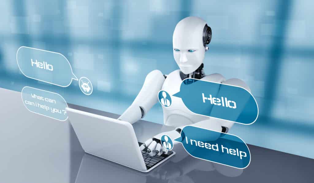 A humanoid robot sitting at a table, using a laptop to answer customer service questions.