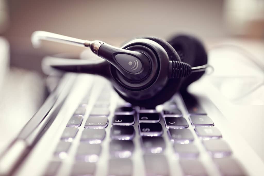 A headset sits on top of a computer keyboard.