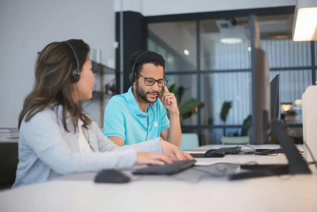 An agent shares call center coaching techniques and tools with another agent to develop best practices.