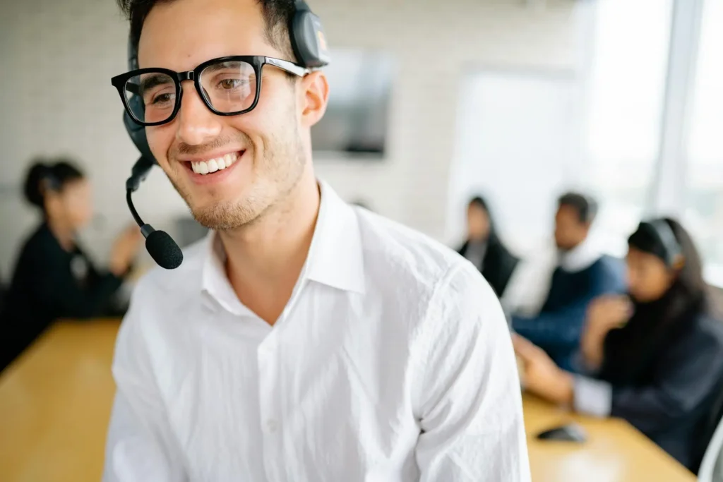 A call center agent smiles after a coaching session where they received coaching tips and best practices.