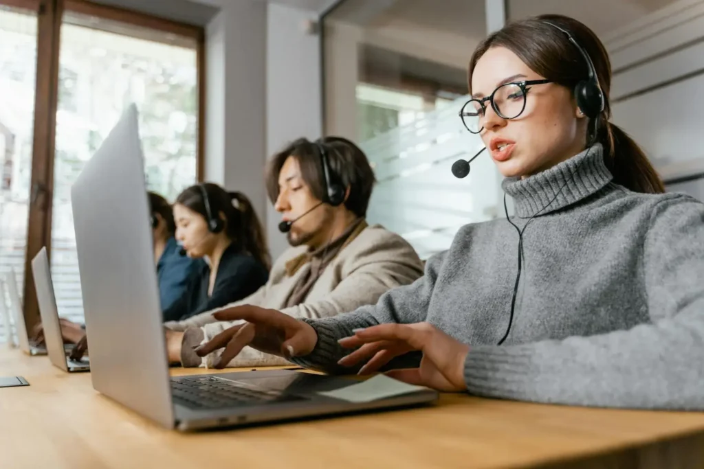 Call center agent and team using AI tools to improve call center customer service through real-time support and analytics.
